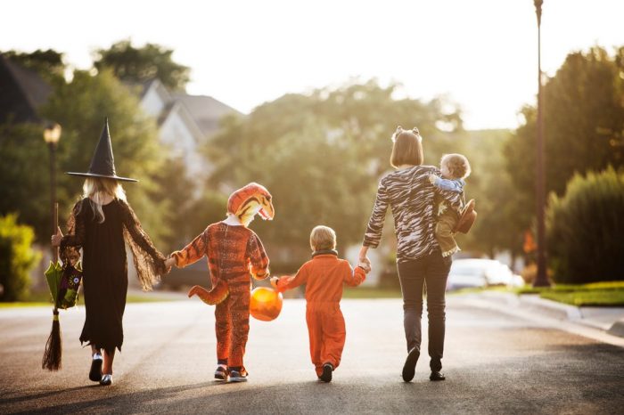 View of a family walking down the street holding hands